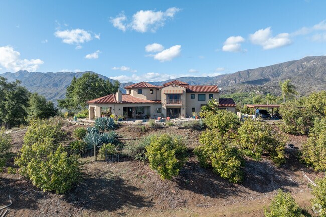 Surrounded by towering oaks and vibrant gardens, this Meiners Oaks home embraces Mediterranean design with its arched doorways, terracotta accents, and warm earth tones.