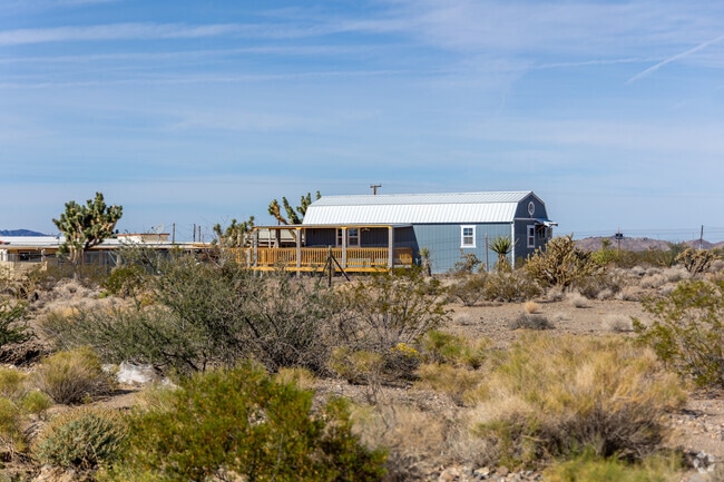 Modern manufactured homes with wooden decks sit on open lots.