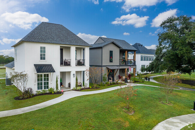 A row of multi-story homes sit along a quaint sidewalk in Scott, Louisiana.
