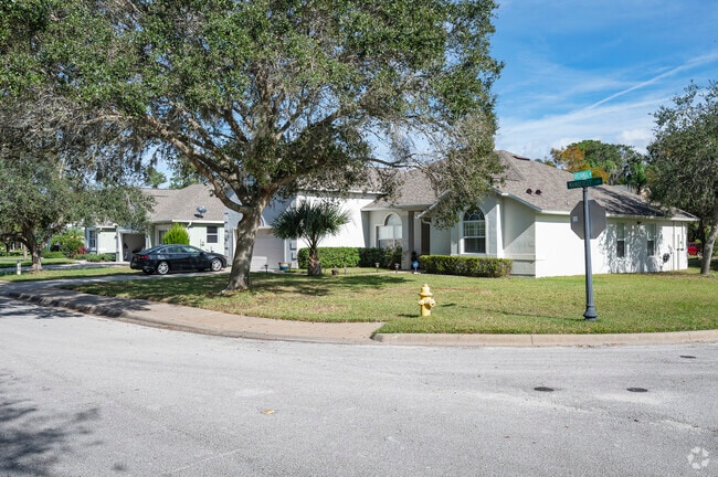 A row of Lakevue single‑family homes sits beneath mature native trees in Ormond Beach.