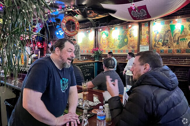 Morgan, one of the co-owners of the Cat's Eye Pub in Fells Point, chats with a customer.