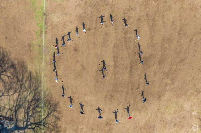 Baseball players circle up to begin their stretches as a team before starting practice at Sullivan Memorial Park in Montrose.