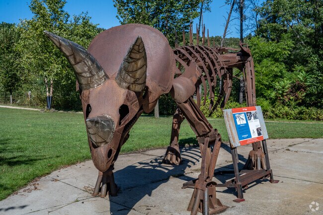 Take a photo with the dinosaur statues at River Prairie Park.