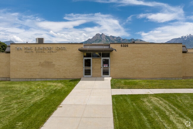 A sidewalk leads to an entrance to Twin Peaks Elementary School.