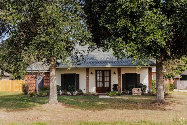 An Acadian-style home framed between two trees in North Lafayette Parish.
