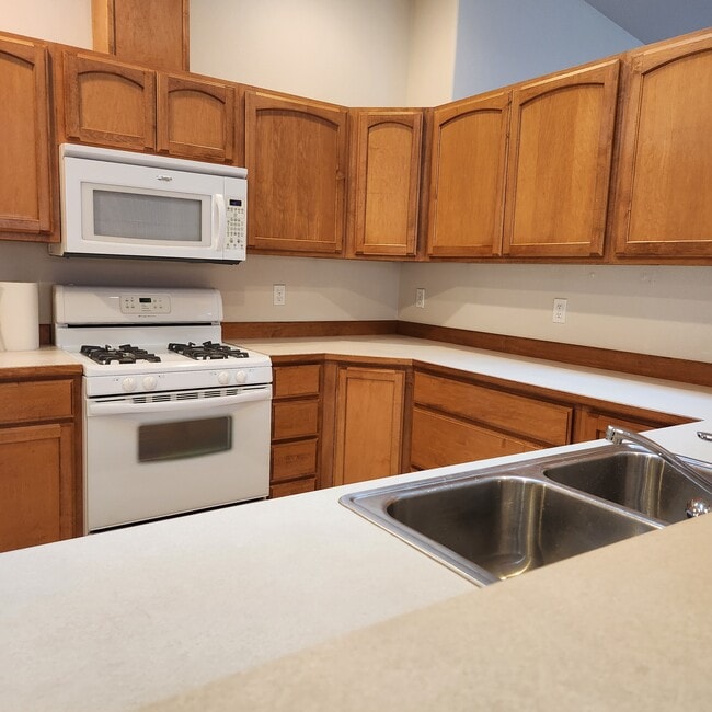 Kitchen has gas range, new flooring, pantry, and skylight.