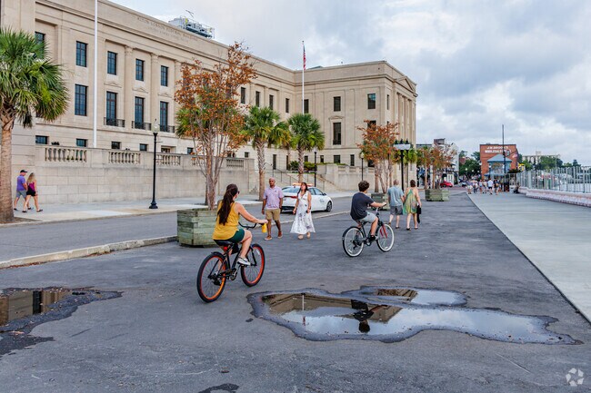 Friends from Carolina Place bike past the Federal Building in downtown Wilmington.