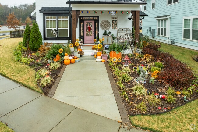 A decorated front porch with pumpkins and vegetation in a neighborhood in Catawba.