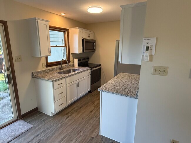 Modern kitchen features new cabinetry, granite countertops, and stainless steel appliances