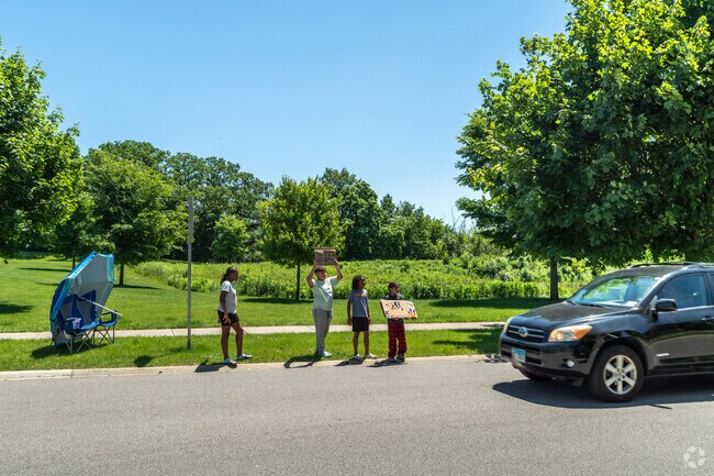Kids stand by Heatherstone Community Park to sell lemonade to passing cars.