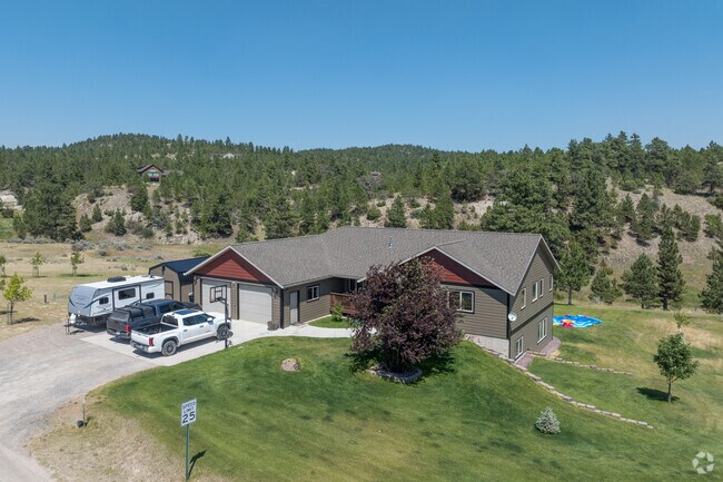A stylish house sits on a ridge framed by the woods in Birdseye.