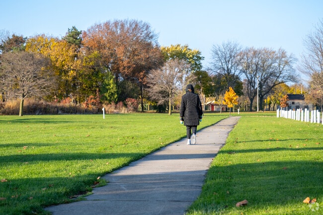 Residents walk Hyde Park’s paved paths lined with trees and seasonal scenery.