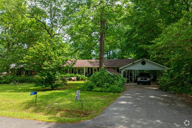 Tucked beneath a canopy of mature trees, this classic ranch-style home in Towaliga Shores offers a cozy, shaded retreat.