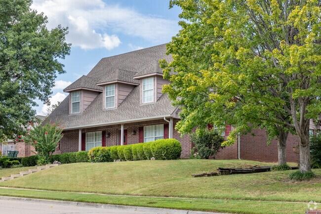 Owasso's beauty is shown in home with mature trees.