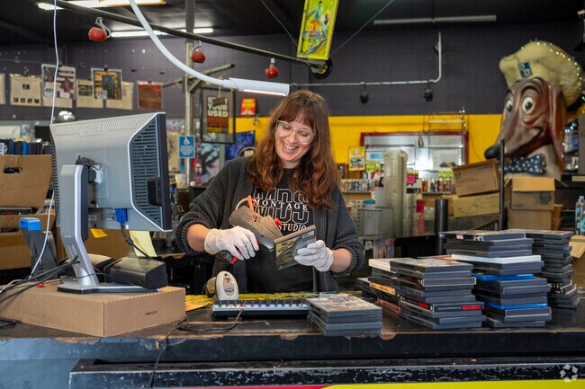 A streetlight Records employee putting price tags on the DVDs in the Fruitdale neighborhood.