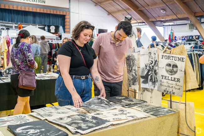 Vintage Fest attendees look through printed antique posters at The DuPage County Fairground.