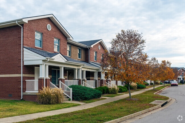 A row of two-story brick townhouses showcases exquisite landscaping in Wilmore.