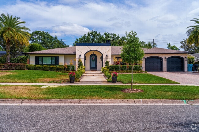 This Rose Isle home features an arched entry, lush landscaping, and great curb appeal.