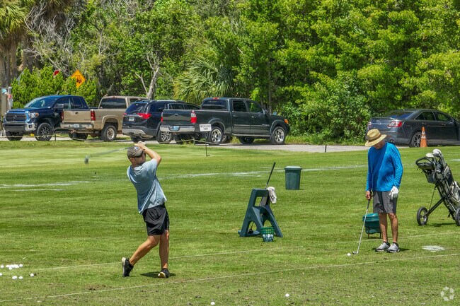 Golfers practice their swing at the golf course near Bayou Club.