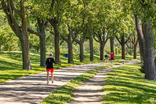 Residents enjoy the tree-lined trails with a view of the lake at Bde Maka Ska.