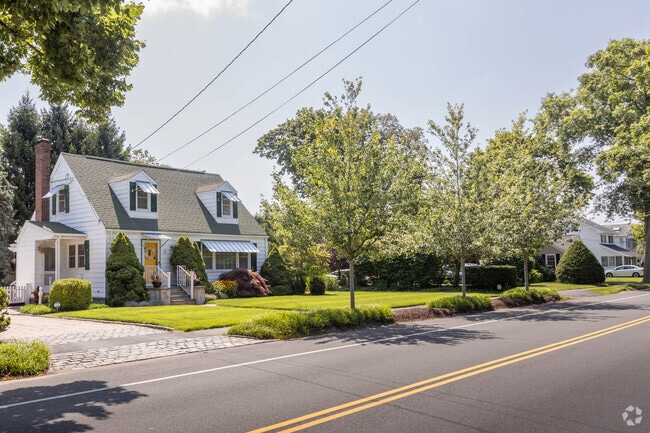 Cape Cods with well-manicured lawns line Main Street in Bellport Village.