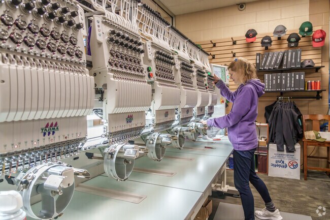 A woman preps a cap for embroidering at this shop in Chester Township.