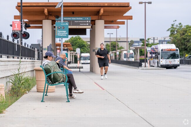 Commuters wait for their buses beneath the station’s tall arched windows and vintage-style lamps.