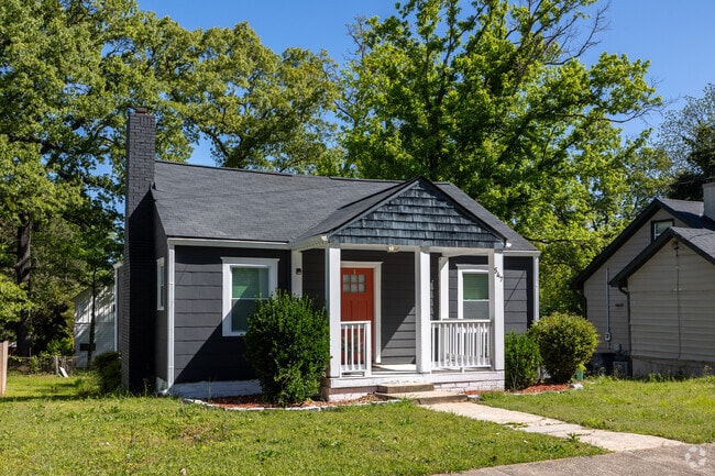 A charming small bungalow home with a red door in Hapeville, GA.