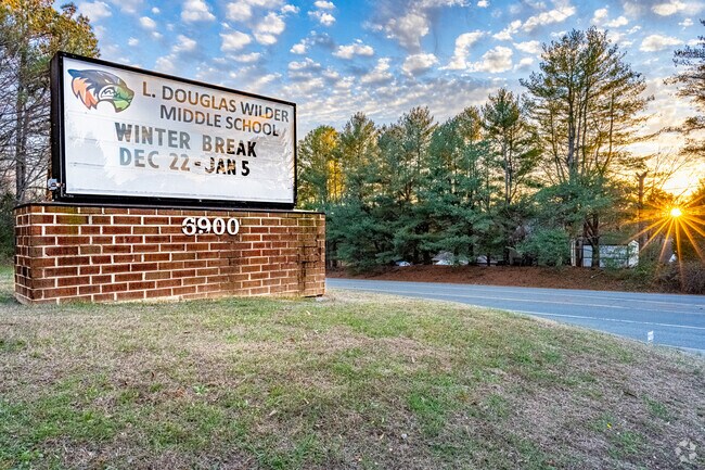 The sun is setting next to the monument sign for L. Douglas Middle School.