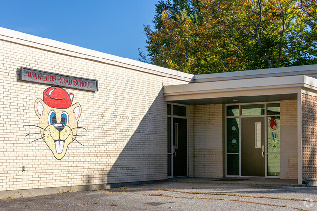 Wawecus Road School's signage and mascot on the side of the building.