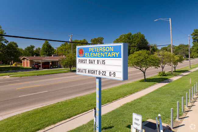 The sign for Peterson Elementary School is near the street.