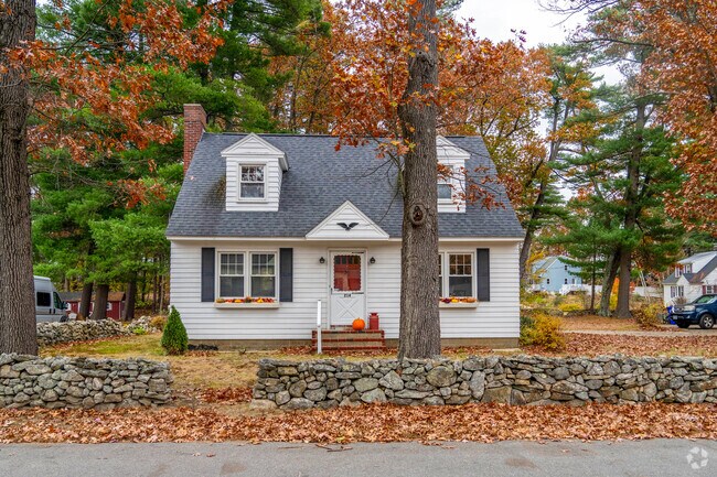 A cape style home in Wolfe park has a stone wall surrounding the leaf covered property.
