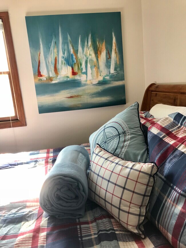 Nautical themed bedroom with comfortable new mattress and bedroom furniture.