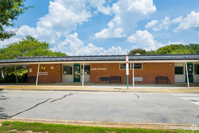 The Maybeury elementary school sits within a luscious tree canopy.