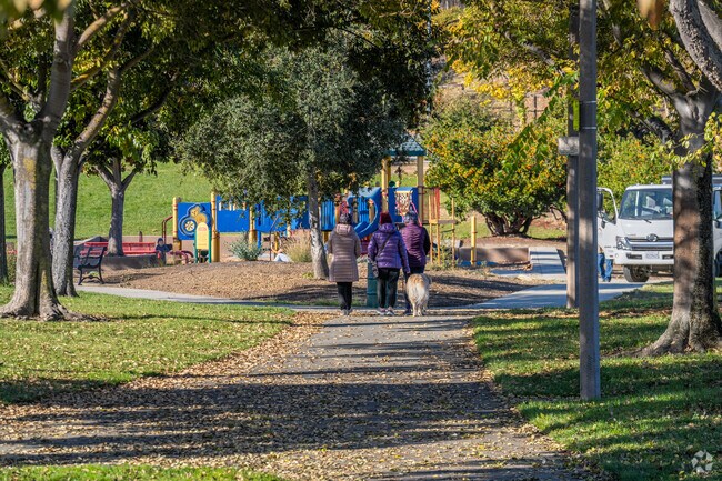 Residents walk shaded paths by the playground in Glenview Park near Glenview Serenity.