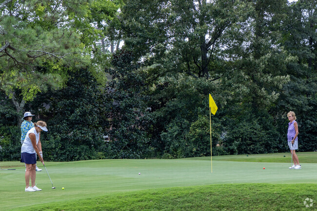 Three women enjoy a relaxing round of golf, chatting and hitting the greens.