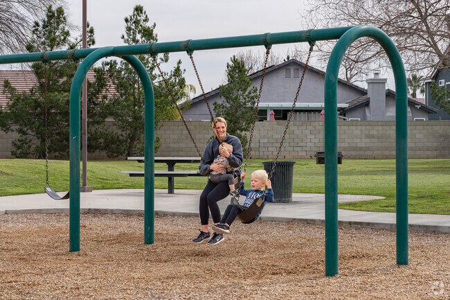 An Emerald Estates mother enjoys swinging with her boys at Polo Community Park.