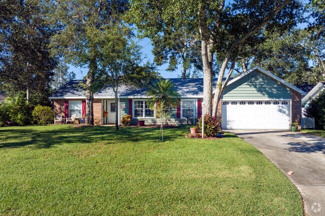Mature trees and impeccable lawn care grace this brick-accented Northbrook ranch-style home.
