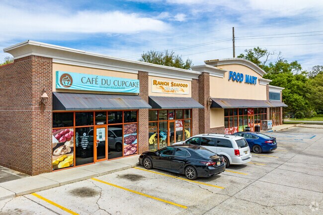 A small shopping center with food market and dining options in Autumndale.
