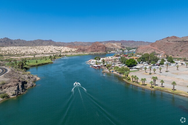 Boats drift past floating bars and waterfront homes along the Colorado River in Parker.