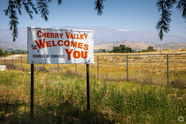 Local sign with the San Bernardino Mountains seen the background in Cherry Valley.
