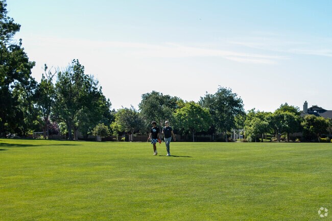 A father and son walking in grass at El Quito Park in the Bucknall area.