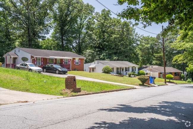 Homes in Fairburn Heights reside on wide hilly streets and are surrounded by a canopy of lush green trees.