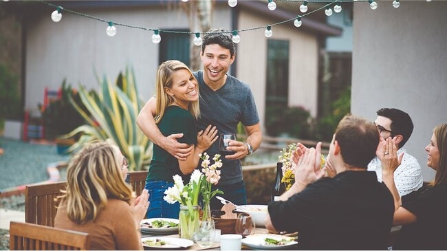 Couple hugging with friends at a table