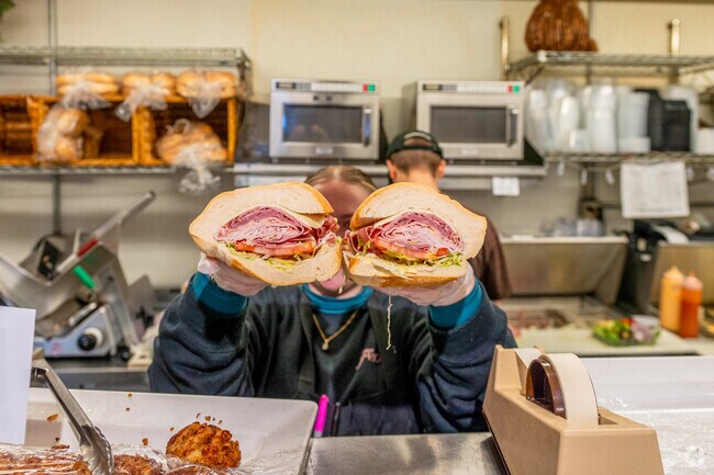 A worker at Frigo's Gourmet Foods in East Longmeadow displays the contents of a sub.