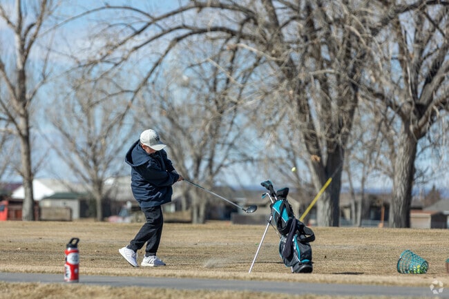 A young child practices his swing at Pryor Creek Golf Club, embracing the sport early.