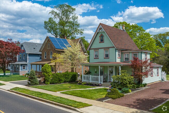 A row of homes on E. Taunton Ave in Berlin, featuring a colorful Victorian home.