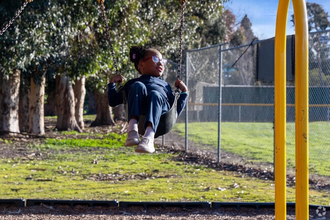 Joyful heights Little girl swinging at City Park in River Run.