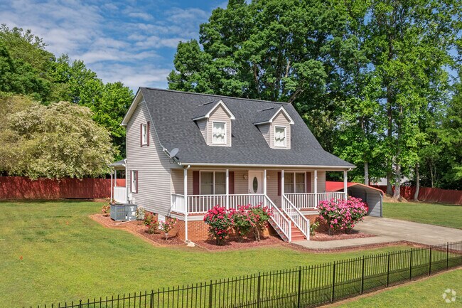 This Liberty cape cod features vibrant landscaping and a wide front porch.