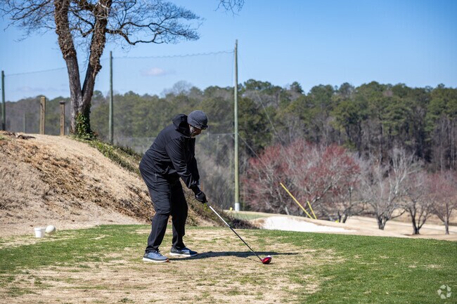 A golfer is about to tee off at College Park Golf Course, located near the Cherry Blossom neighborhood.